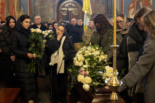 지난 2일(현지시간) 우크라이나 키이우의 성 미하일 대성당에서 열린 자원병 전사군인 볼로디미르 라코프의 고별식에서 유족들이 애도하고 있습니다. 그는 유명한 무용가이자 안무가였습니다. AP 연합뉴스